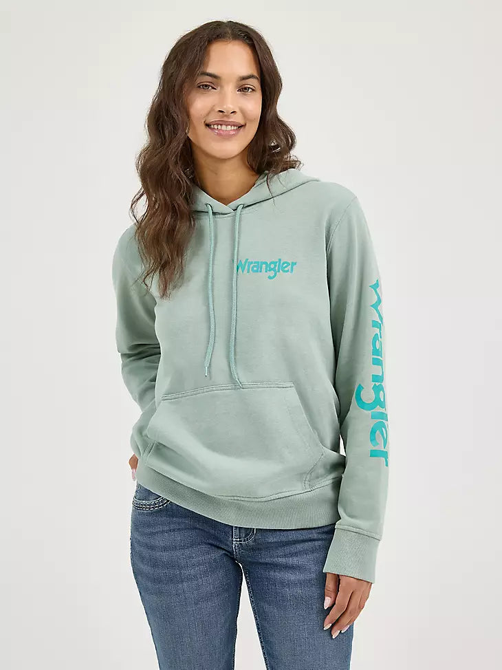 Woman wearing a light green hoodie with 'Wrangler' branding on a white background