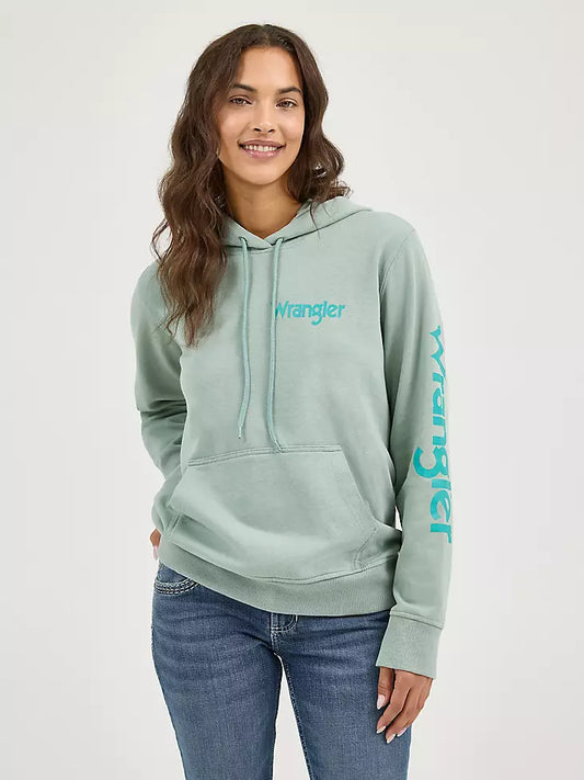 Woman wearing a light green hoodie with 'Wrangler' branding on a white background